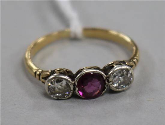 An early 20th century yellow metal and three stone diamond and garnet ring, size M.